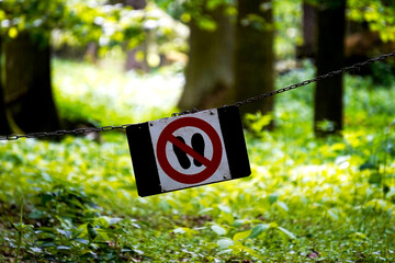 Sign prohibiting walking on the grass, placed in a green public area. A gentle reminder to protect...
