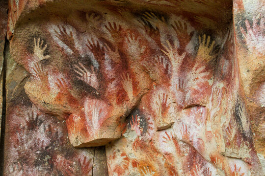 Cave of Hands in Argentina, cueva de las manos. Cave with hand arm prints on walls. Handprints made with red, yellow and black paint of ancient people on ceiling of a cave. Ancient rock carvings