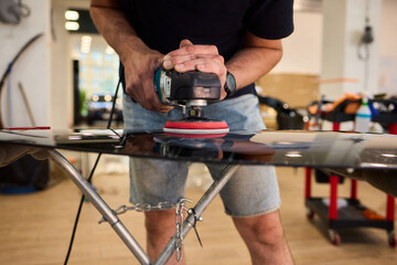 A professional technician expertly polishes glass surfaces in a workshop with precision