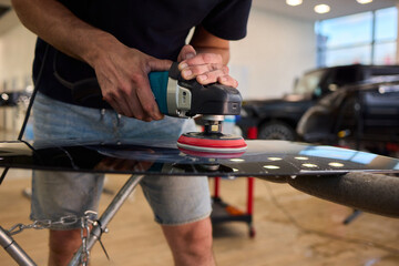 Obraz premium A professional technician expertly polishes glass surfaces in a workshop with precision