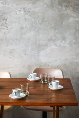 Empty coffee cups and glasses on wooden table in cafe for coffee break