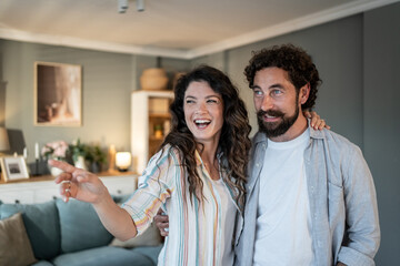 Happy couple planning future home decor in living room