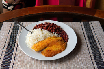 Breaded tilapia fillet with rice and beans, a healthy dish