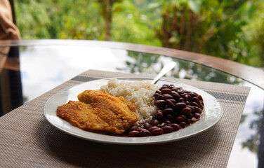 Breaded tilapia fillet with rice and beans, a healthy dish