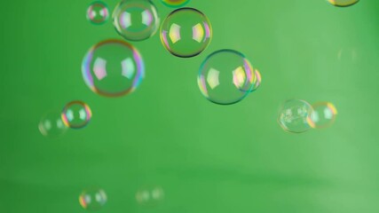 Colorful soap bubbles floating on a vivid green screen, perfect for video overlay and effects, Transparent animated bubbles with rainbow reflections on a chroma key background, Playful green screen 4K - Powered by Adobe