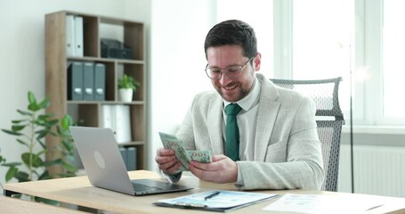 Greedy banker counting money and smiling at table in office - Powered by Adobe