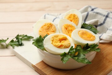 Boiled eggs and parsley on wooden table, closeup