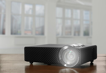 Modern video projector on wooden table in room