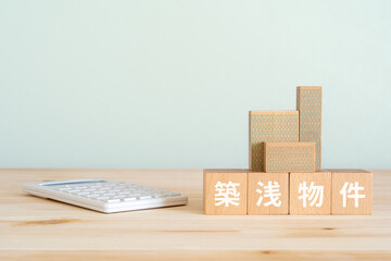 築浅物件と書かれたブロック、不動産の模型、電卓