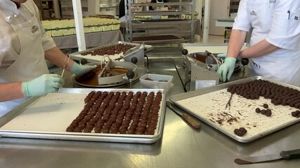 Confections chocolate factory workers preparing dipped Chocolate balls in Kitchen