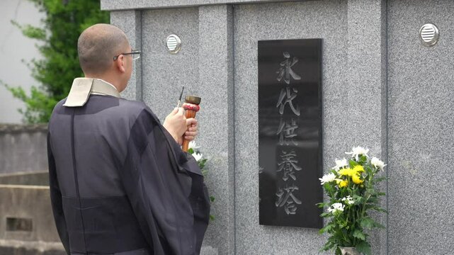 永代供養塔で読経するお坊さん