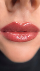 permanent makeup on the lips of a young woman of a delicate peach shade close-up, a girl after a...