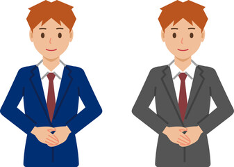 手を前で重ねて立つショートヘアの若い男性。スーツ姿の上半身