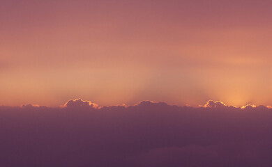 Fototapeta premium Golden sunset over a serene landscape, warm light through clouds, orange and purple hues blending in harmony 