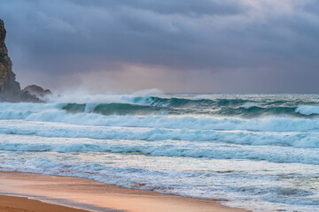 Moody sunrise with waves at the seaside