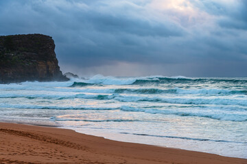 Moody sunrise with waves at the seaside