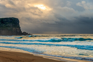 Moody sunrise with waves at the seaside