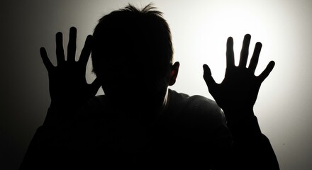 Silhouette of a man with hands pressed against translucent surface