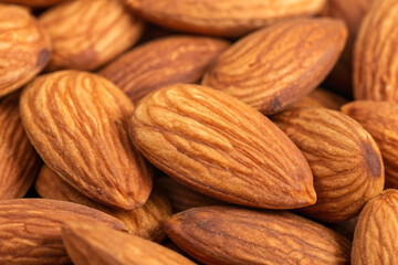Fototapeta premium A pile of Almonds, isolated on a wooden background