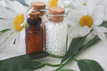 Bottles of homeopathic medicine and flowers with natural decor