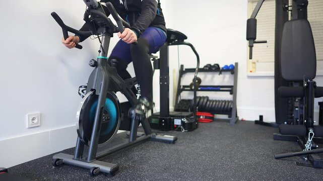 Man pedaling very fast on an exercise bike in his home gym
