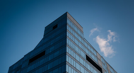 Fototapeta premium Modern Glass Facade of a HighRise Building Against a Clear Sky