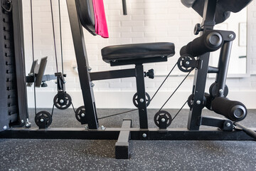 Weight machine with pulleys and weight discs to improve strength and muscles.