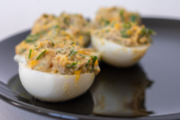 Stuffed eggs on a black plate, traditional appetizer with creamy filling, perfect for Easter or festive gatherings.