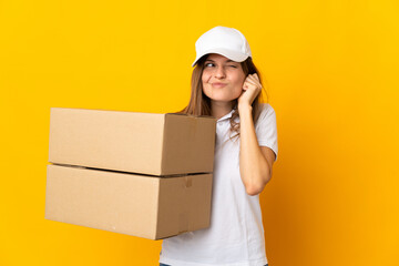 Young Slovak delivery woman isolated on yellow background frustrated and covering ears