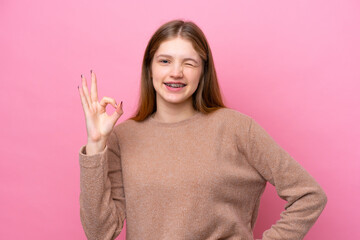 Teenager Russian girl isolated on pink background showing ok sign with fingers