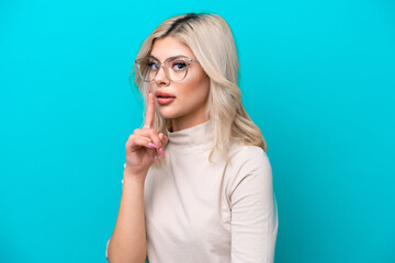 Young Russian woman isolated on blue background With glasses and doing silence gesture