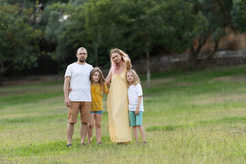 Fototapeta premium Happy family of four enjoying summer day in park