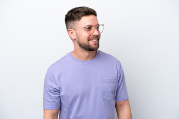 Young caucasian man isolated on white background looking side