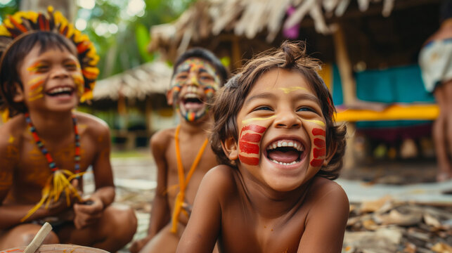 Indigenous children laughing together with painted faces and traditional attire.
