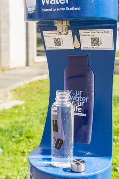 Fort William, Scotland, United Kingdom - August 17, 2023: Close-up of a reusable bottle being refilled at a free public fountain.