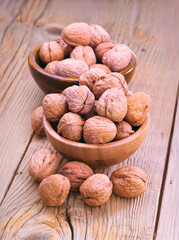 Walnuts filling two wooden bowls resting on rustic table