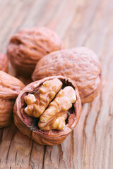 Walnuts cracked open on rustic wooden table displaying nutritious seed