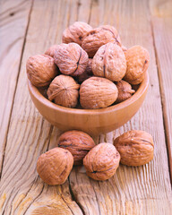 Walnuts filling a wooden bowl on rustic table
