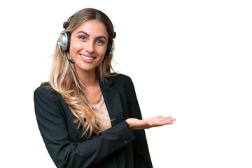 Telemarketer pretty Uruguayan woman working with a headset over isolated background presenting an idea while looking smiling towards
