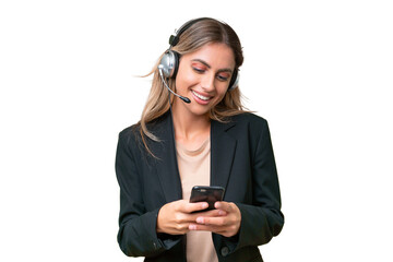 Telemarketer pretty Uruguayan woman working with a headset over isolated background sending a...