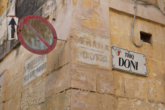 Weathered Street Signs and Vintage Road Symbol on Triq Doni in Rabat, Malta..