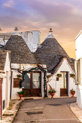 fancy beautiful buildings trulli with white old walls and strange roofs on a blue sky background of...