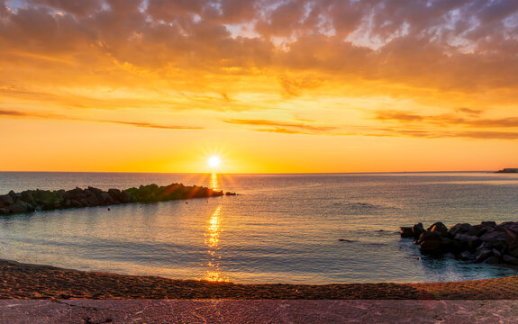 morning or evening landscape with nice beach during sunrise or sunset in sea with amazing isle with rocks and beautiful clouds on background - Powered by Adobe