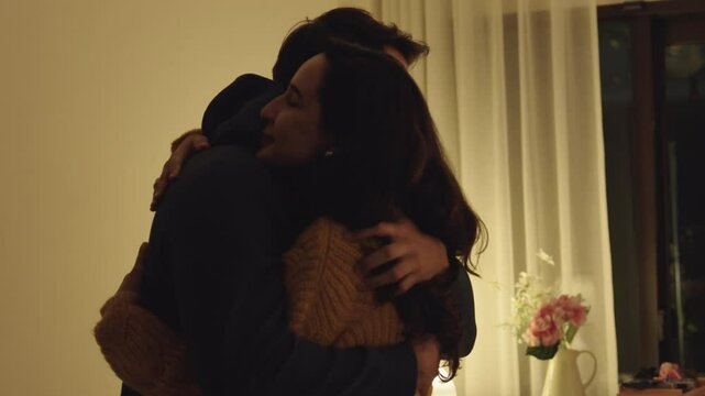 Loving couple hugging romantically together at home, happy in their relationship with deep affection and heartfelt reconciliation