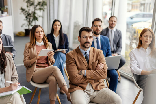 Group of managers sitting at boardroom on seminar and listening lecture.