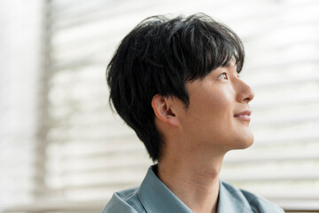 微笑んでいる若い日本人男性の横顔。