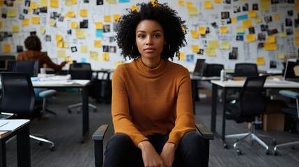 Confident young woman sitting in an office space surrounded by creative ideas and inspiration