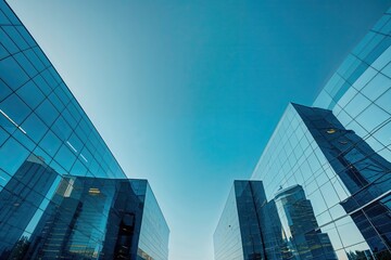 Fototapeta premium Stylish Corporate Offices Featuring Sleek Glass Facades Under a Bright Blue Sky