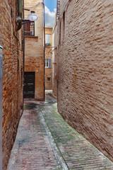 Obraz premium Narrow, brick-lined alleyways of Urbino, Italy, where medieval architecture and cobblestone streets create a timeless atmosphere. Urbino, Marche region, Italy