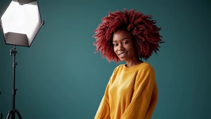 Woman with vivid red curly hair in bright yellow sweater near blue wall highlights individuality personal expression uniqueness style creative freedom